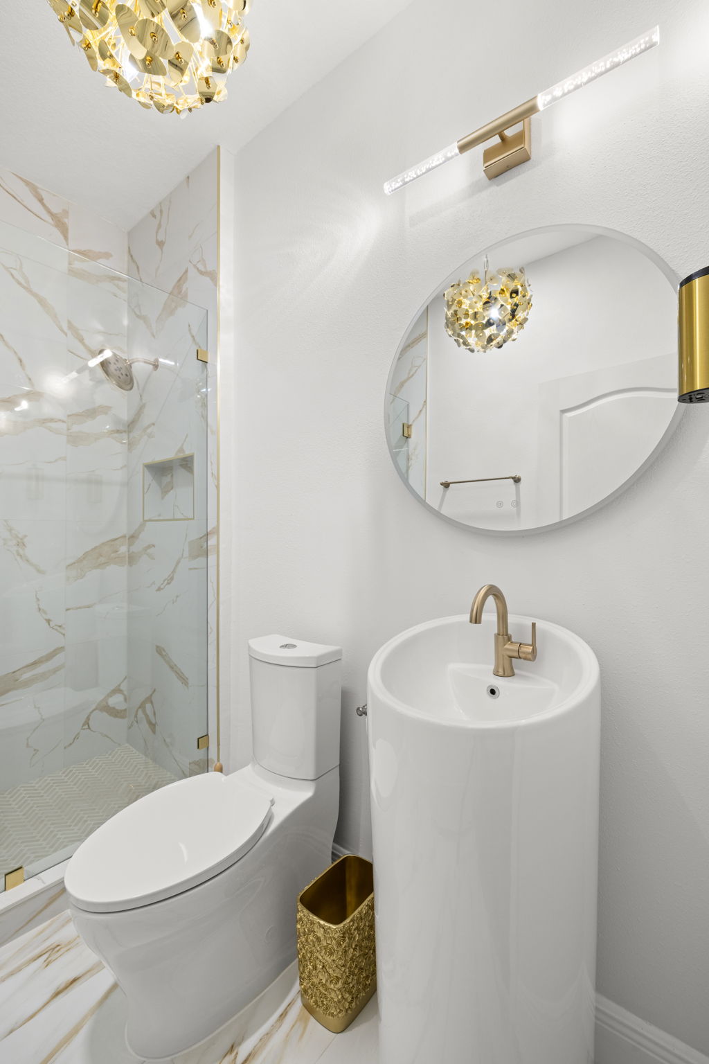 Modern bathroom with gold accents and marble shower.