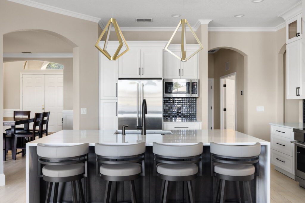 Modern kitchen with island and gold pendant lights.
